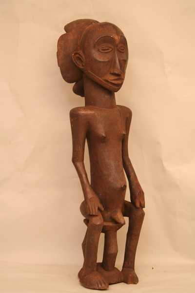 HEMBA (statue  assis)), d`afrique : Rép.démoncratique du Congo., statuette HEMBA (statue  assis)), masque ancien africain HEMBA (statue  assis)), art du Rép.démoncratique du Congo. - Art Africain, collection privées Belgique. Statue africaine de la tribu des HEMBA (statue  assis)), provenant du Rép.démoncratique du Congo., 1496/1285.Ancienne belle statue Hemba h.99cm
Ancêtre royal assis sur un trone,les deux mains sur les genoux;Allure royale,coiffure à quatre lobes avec deux tresses posés en croix;1ère moitié du 20eme sc.bois avec vieille patine,de la laque noire dans le creux de la tête,pour désacraliser la pièce avant d